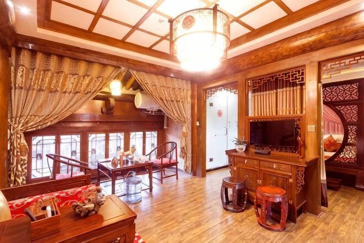 Une chambre traditionnelle, dotée de meubles en bois, d’un lustre et offrant une vue sur l’extérieur.