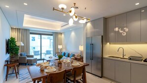 A modern kitchen with a built-in oven, a sink, and a dining area with a table set for four.