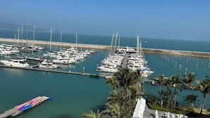 A marina with numerous boats docked, a clear sky, and a calm sea. - L.V.BAY (Shenzhen)