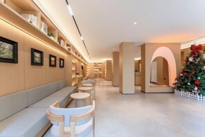A hotel lobby with a long reception desk, seating area, and a Christmas tree. - Dayang Hotel (Harbin)