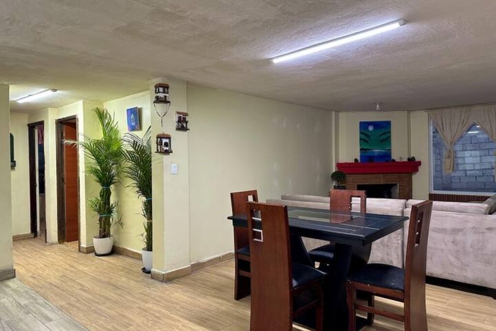 Ein Essbereich mit Tisch, Stühlen, einer Couch und einem Kamin.