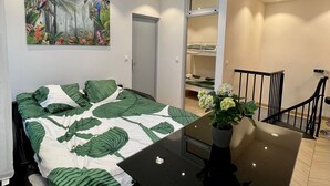Une chambre à coucher avec un lit, un tableau, une table avec un vase et une armoire.