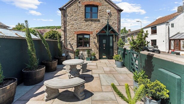 A stone house with a green door, a small porch, and potted plants. - Gorgeous 3 Bed, 225 Year Old Cottage (Portishead)