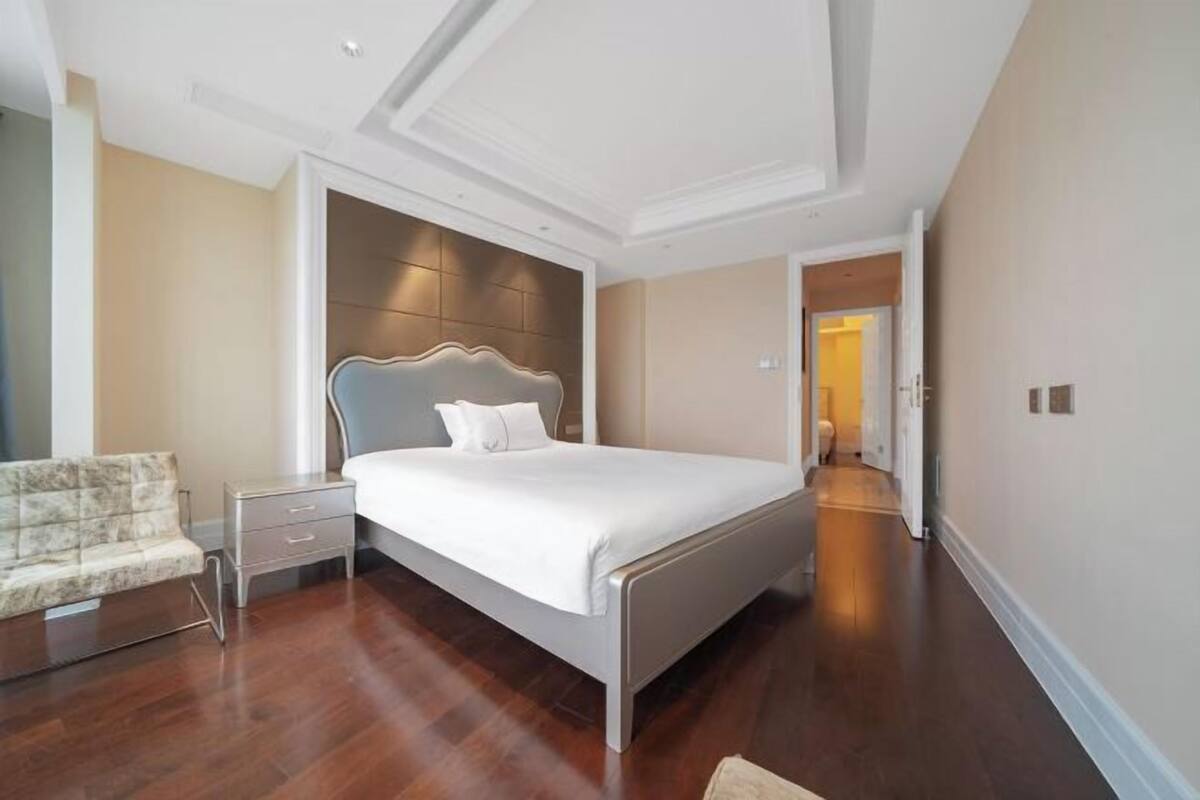 Un dormitorio con cama, mesita de noche y una silla.