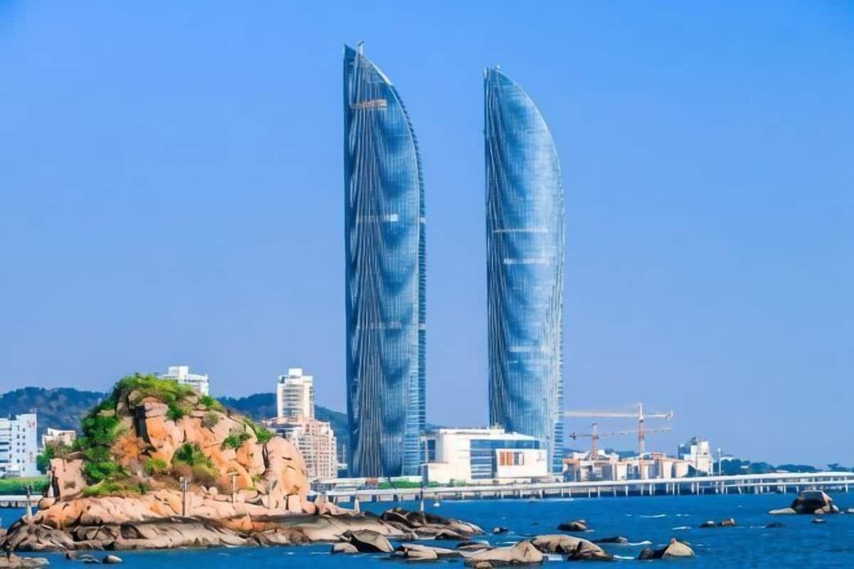 Two tall buildings with a clear blue sky in the background.