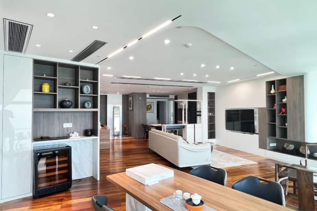 Un interior moderno con área de cocina, comedor y sala de estar con estanterías empotradas y chimenea.
