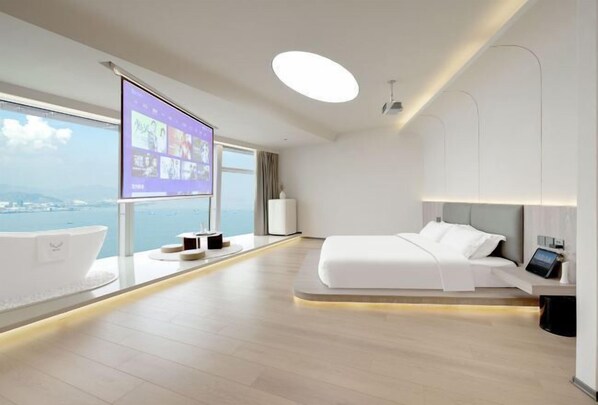 Relax in a spacious room with a large bed, bedside table, and city view.