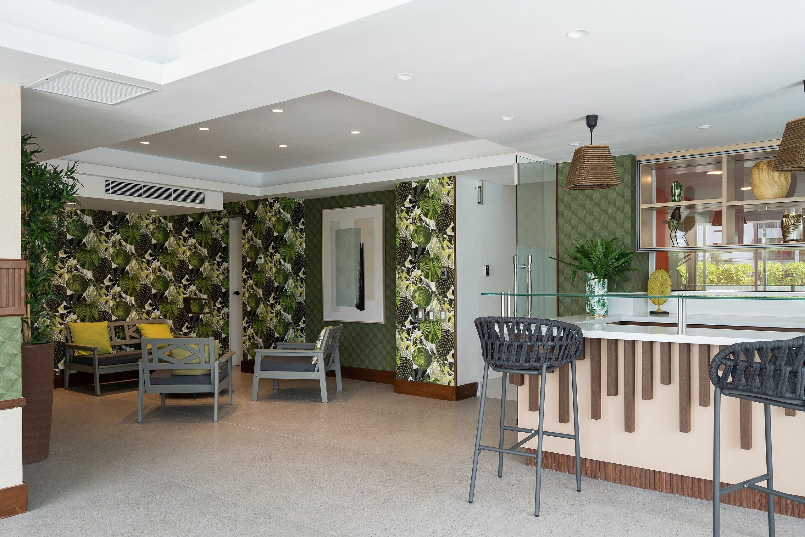 A modern interior with a bar area, seating, and decorative foliage wallpaper.