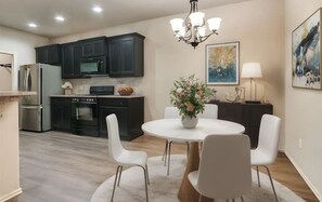Enjoy cooking and dining in this well-equipped kitchen with a dining table for four, refrigerator, microwave, and oven.