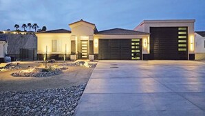 Une maison moderne à deux étages, dotée d ’un garage, d’une allée et d’un espace paysager aménagé.