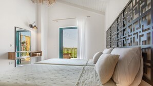 Un dormitorio con una cama grande, vistas al exterior y un panel decorativo en la pared.