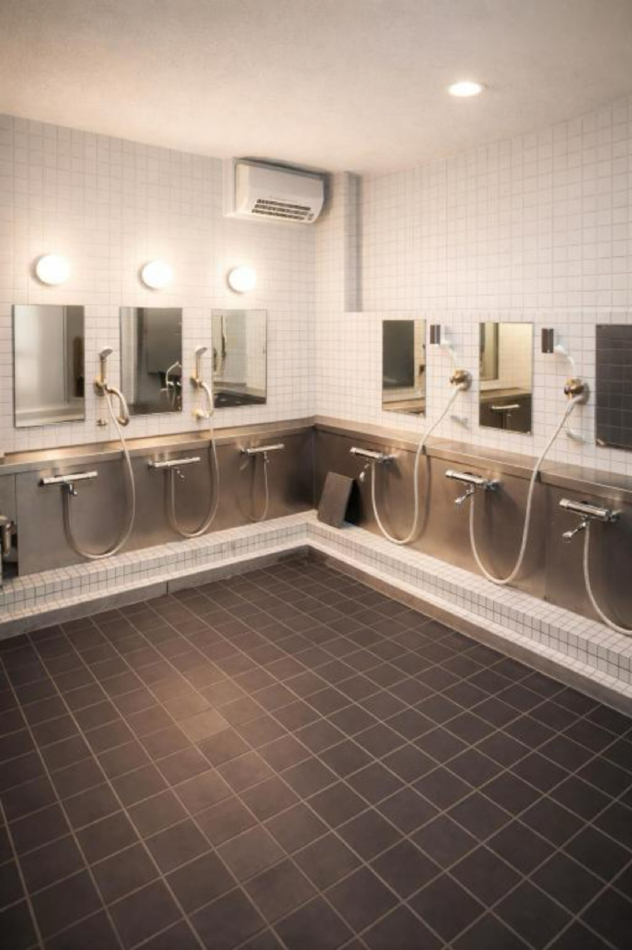 A public restroom with multiple sinks, mirrors, and overhead lighting.