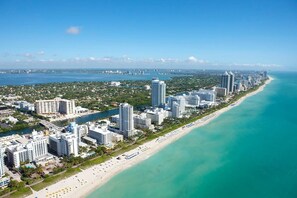 A coastal cityscape with a long beachfront lined with high-rise hotels and a clear view of the ocean. - Quiet Miami Oasis Fast Wi-fi Free Parking (Miami)