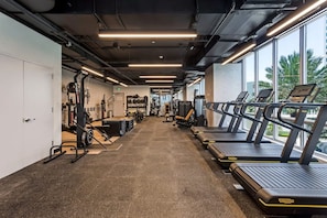 A gym with treadmills, weight machines, and exercise mats.