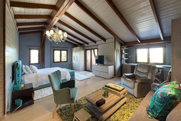 Relax in this stylish loft-style bedroom with a large bed, seating area, and desk.