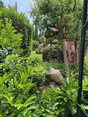 Stroll through a serene garden oasis surrounded by lush greenery and a beautiful pergola.