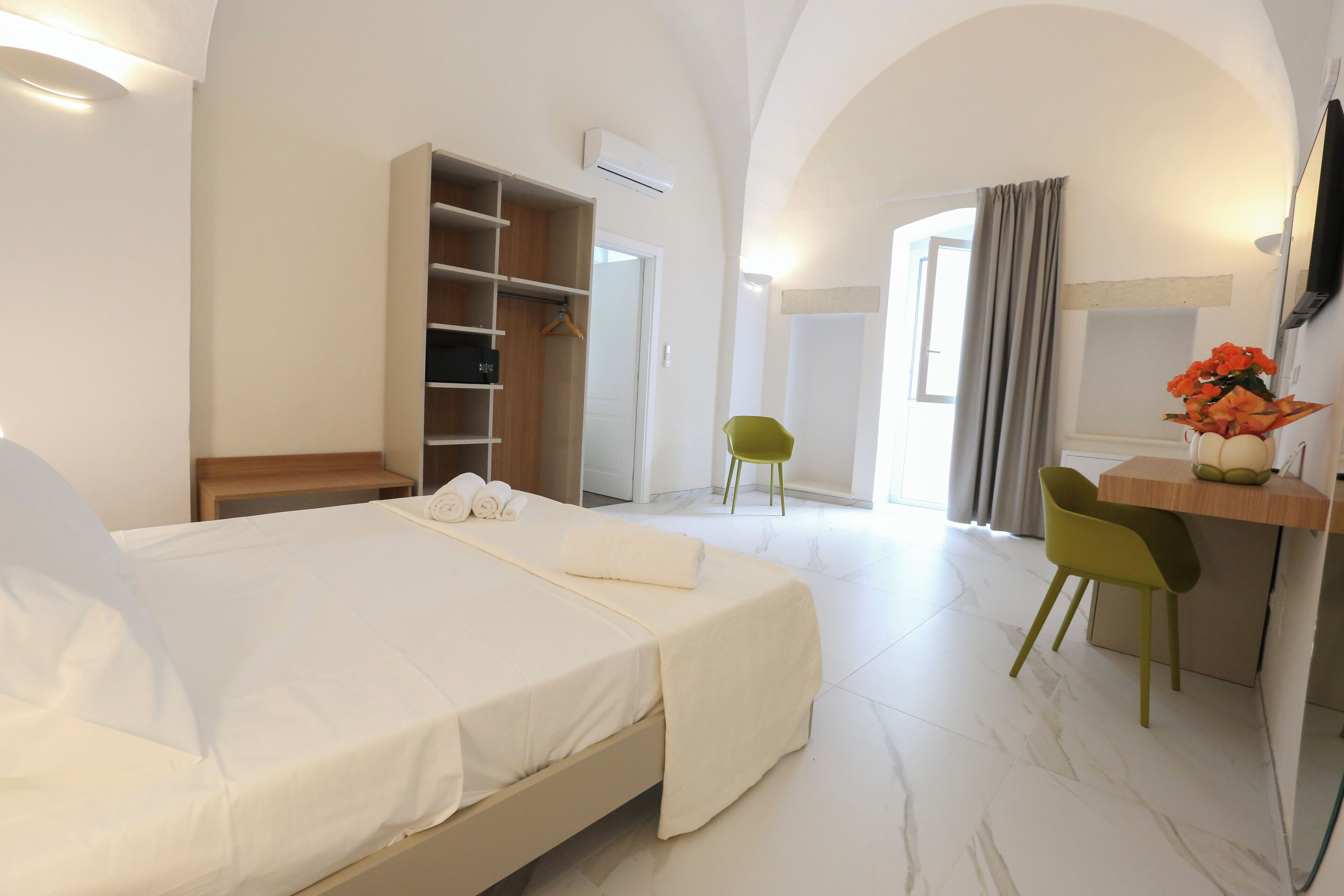 Une chambre d’hôtel comprenant un lit, un bureau, une chaise, une armoire et un téléviseur.