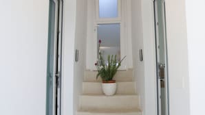 A modern interior with a marble staircase, a potted plant, and a small window at the top. - LE DUE DIMORE (Collepasso)