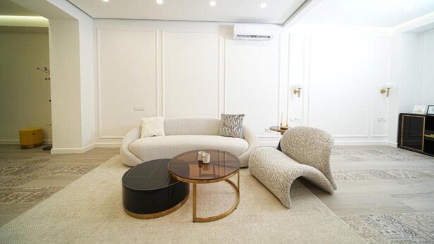 A modern living room with a sofa, a round coffee table, and a chair. - Luxury 2BR apartment in the center (Yerevan)