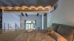 Un dormitorio amplio con una cama grande, un balcón y vistas al exterior.