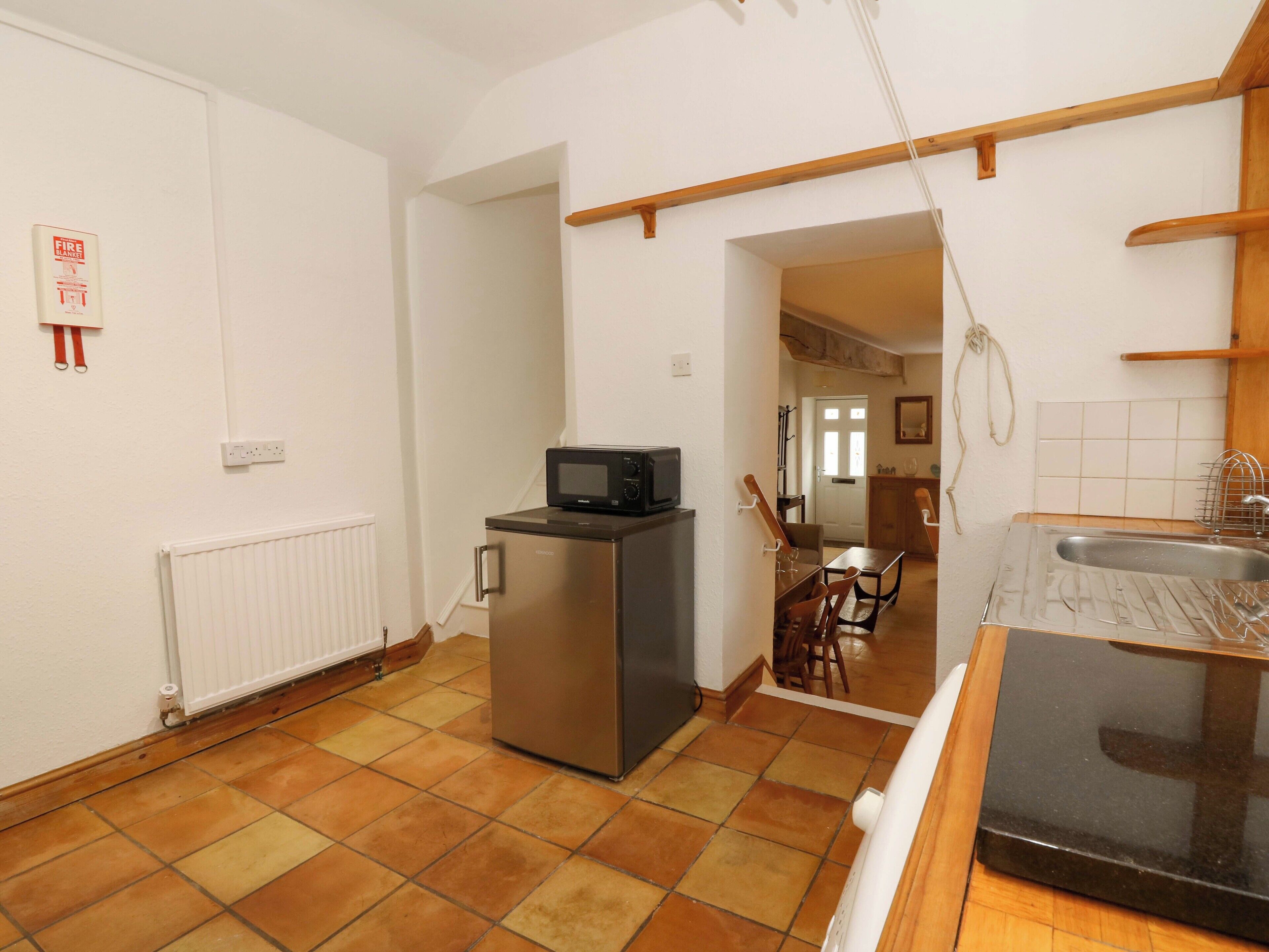 A compact kitchen with a refrigerator, microwave, and sink.