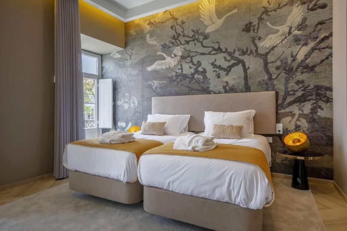 A double room with two beds, a large window, and a wall mural.