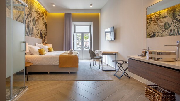 Ein modernes Hotelzimmer mit Bett, Schreibtisch und Bad.