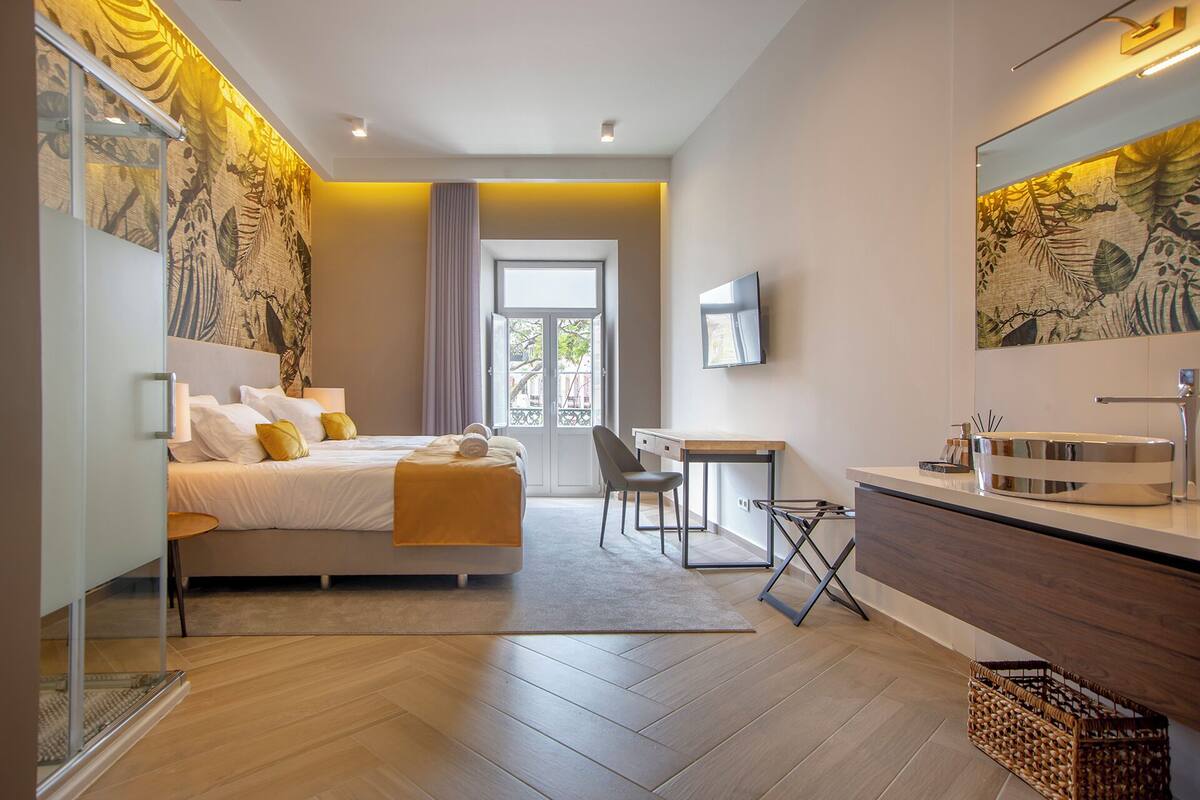A modern hotel room with a bed, desk, and bathroom.