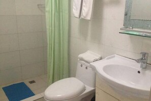 Un baño con inodoro, lavabo y cortina de ducha.
