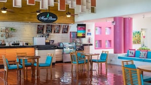 A restaurant with a counter, menu boards, and seating area with tables and chairs.