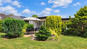 Il s’agit d’une propriété résidentielle dotée d’un patio, d’un espace extérieur aménagé pour s’asseoir et d’une grande variété de plantes et de verdure.