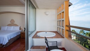 A balcony with a bed, a bathtub, and a view of the ocean. - Stay in Style – 1BR Condo with Balcony & Resort Amenities (Puerto Vallarta)