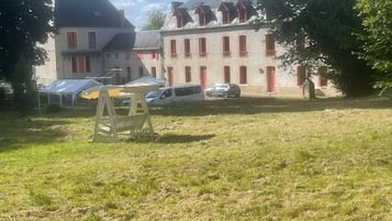 Ein Gebäude mit vielen Fenstern und einer Grünfläche davor.