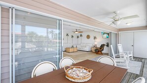 A spacious patio with a dining table, chairs, and a ceiling fan. - Vallie's Villa & Monty's Place (Fort Myers Beach)
