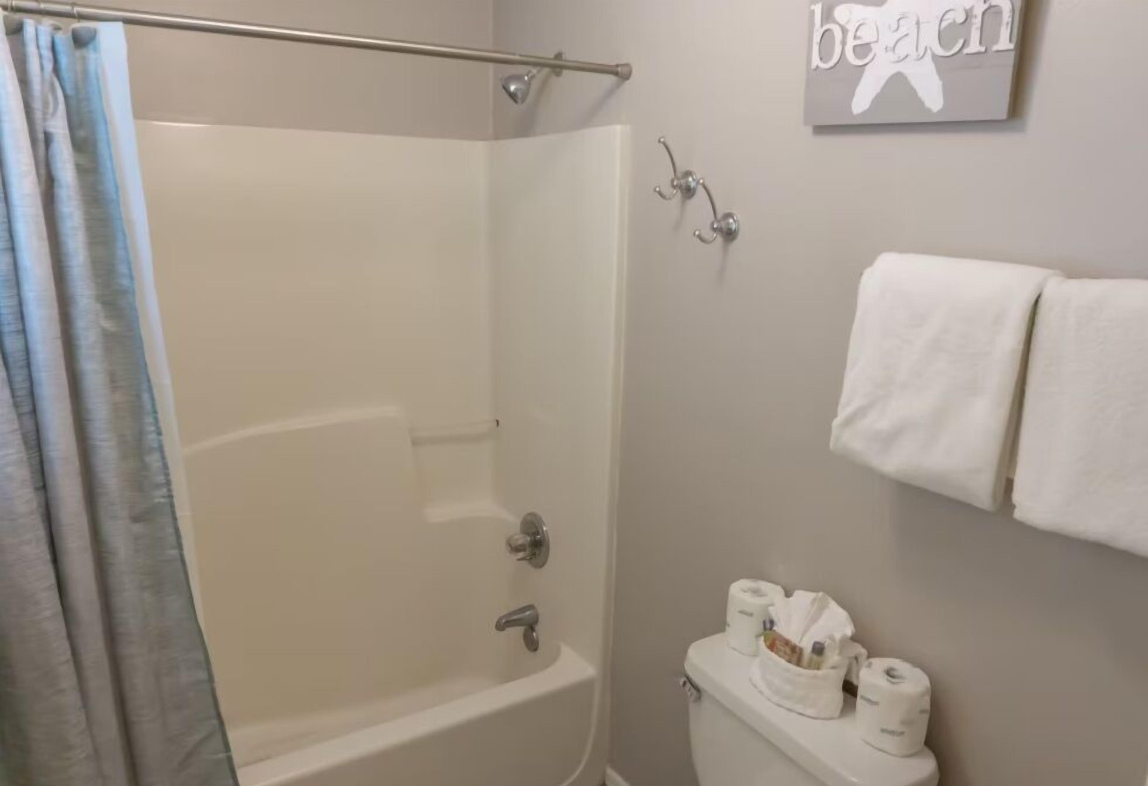 Een badkamer met douche, toilet en handdoekrek.