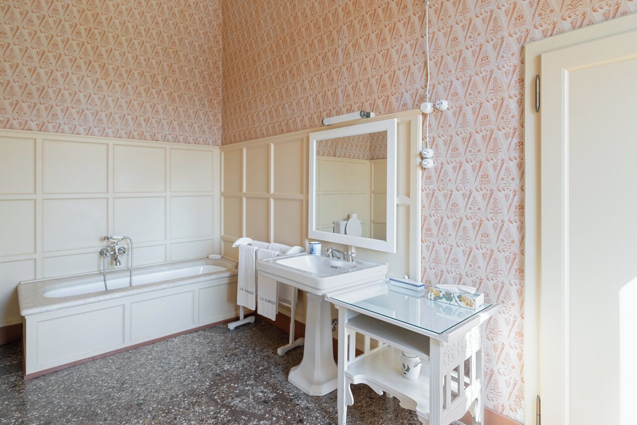 Un baño con bañera, lavamanos y espejo.