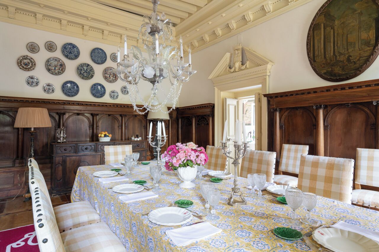 A dining room with a large table set for a meal, surrounded by chairs.