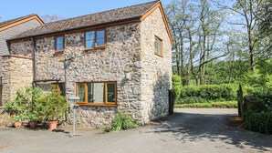 Une maison en pierre avec une allée pavée et un petit jardin.