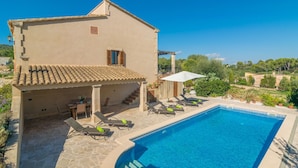 Una villa con piscina, mobiliario de exterior y vistas del paisaje circundante.