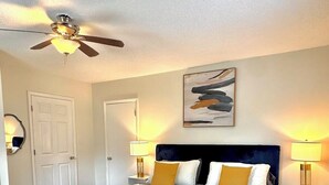 A hotel room with a bed, bedside tables, a ceiling fan, and a floor vent. - HP@The Cottage|Spectrum|Bojangles|NODA|Dogs|Yard (Charlotte)