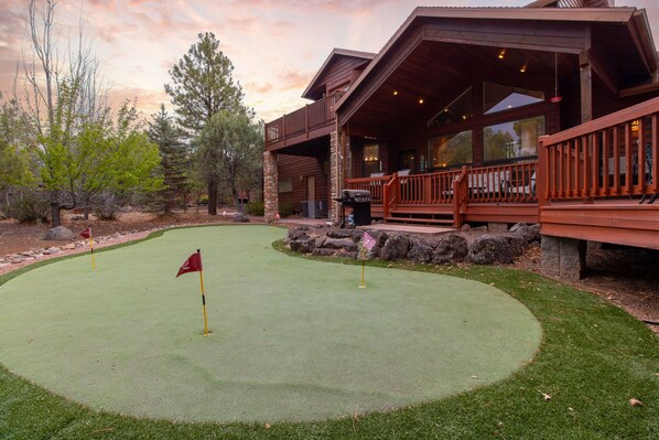 A wooden cabin with a covered deck and a putting green. - European Rustic Mountain Retreat in Torreon (Show Low)