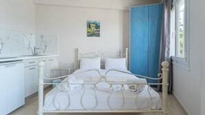 Quarto com cama, guarda-roupa, escrivaninha e um quadro na parede.