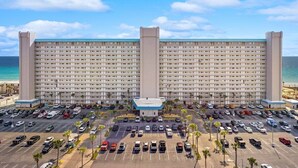 Un grand hôtel à plusieurs étages, doté d’un parking et offrant une vue sur la plage.