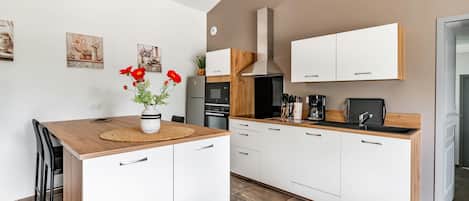 Enjoy cooking in this well-equipped kitchen with a central island, oven, sink, and range hood.