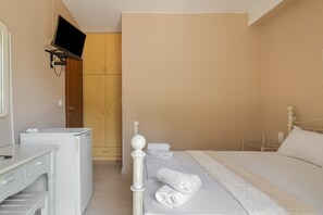 Una camera da letto con un letto, una TV a parete, un armadio e una lavatrice.