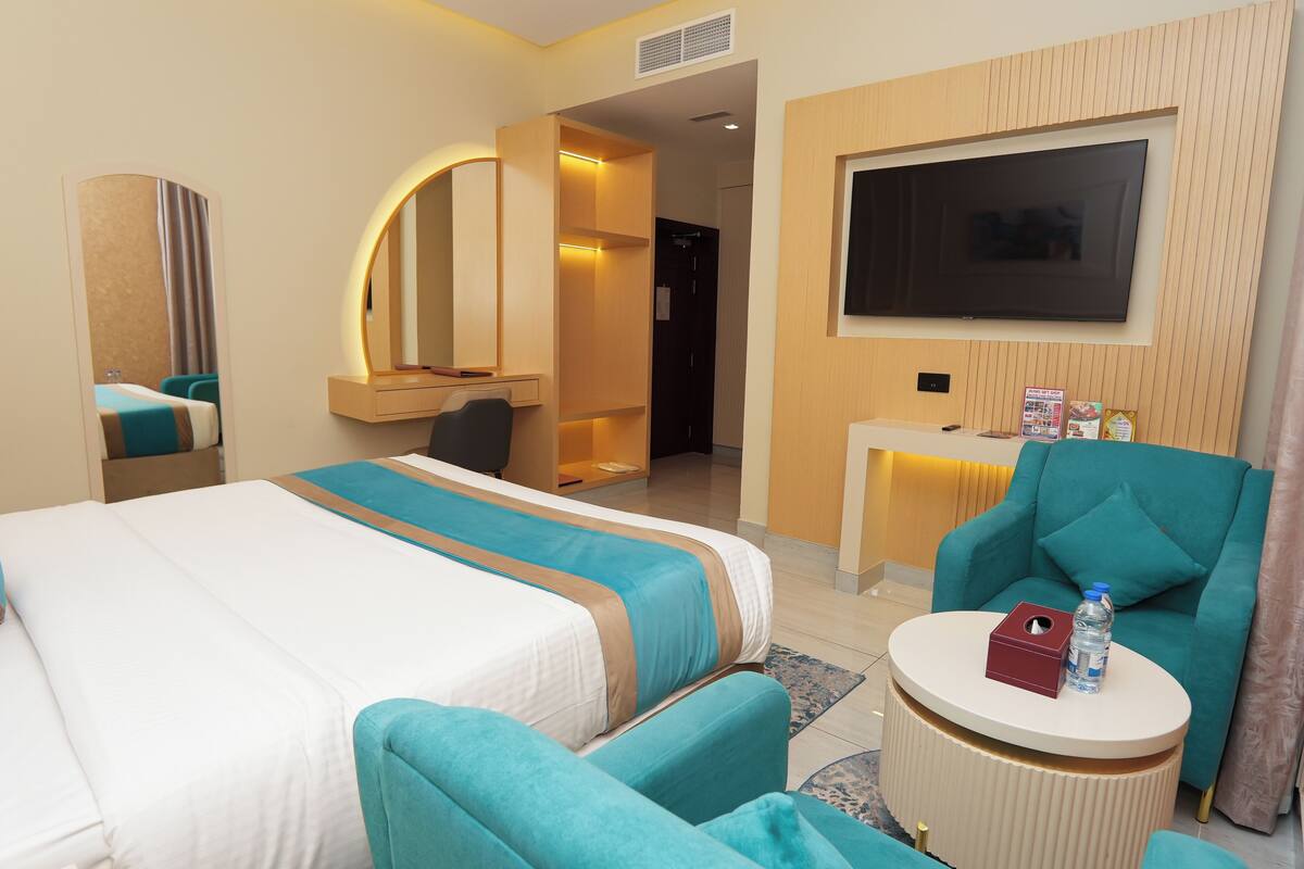Une chambre d’hôtel comprenant un lit, un bureau, une télévision et un coin salon.