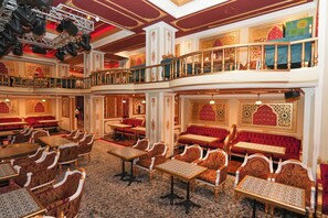 A multi-level restaurant with ornate decor, multiple seating areas, and a balcony with a railing. - Concorde Creek View Hotel (Dubai)