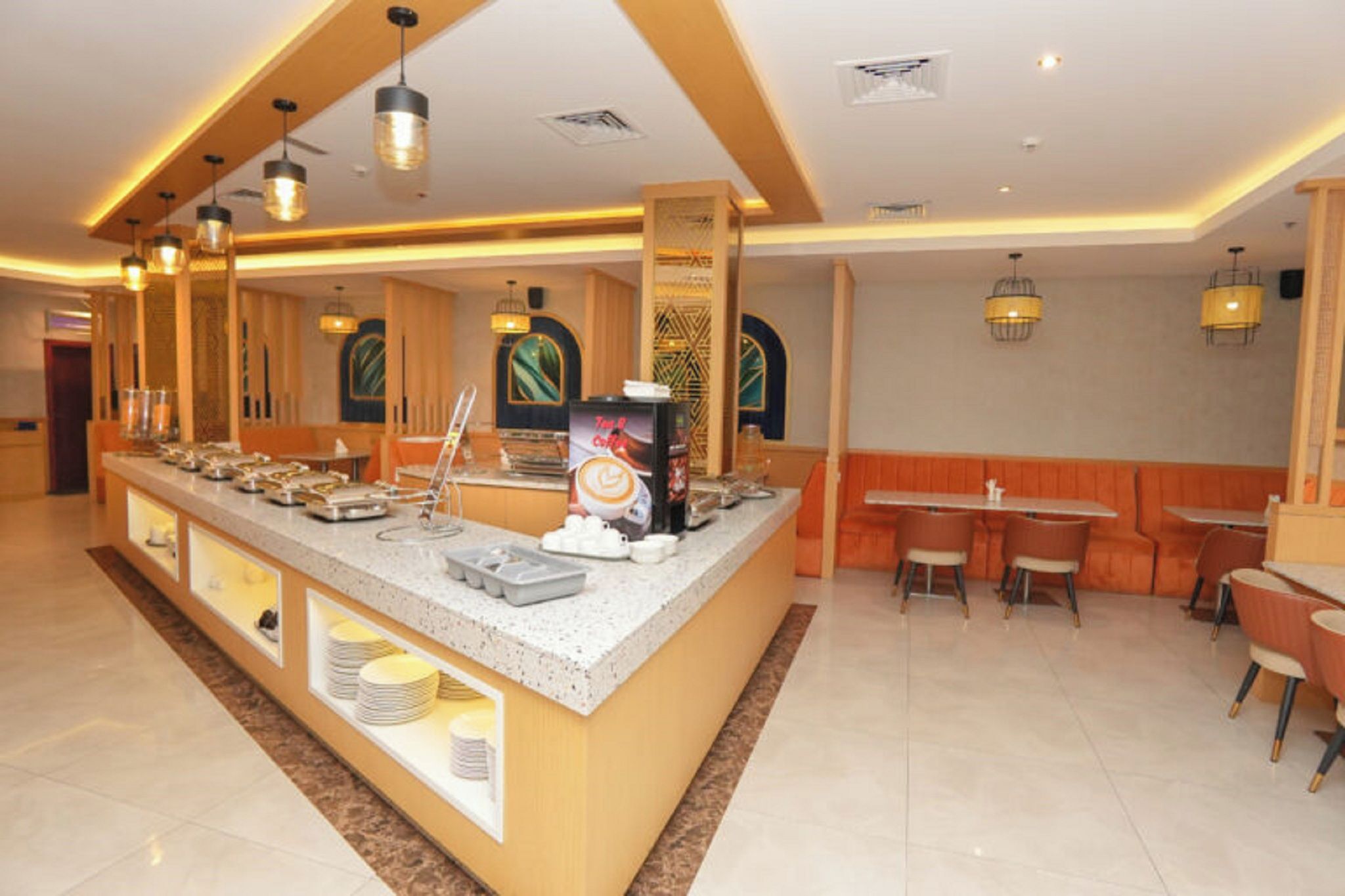 A buffet area with a variety of food stations, a coffee machine, and seating arrangements.