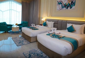 A hotel room with two beds, a sitting area with a chair and a table, and a large window with curtains. - Concorde Creek View Hotel (Dubai)