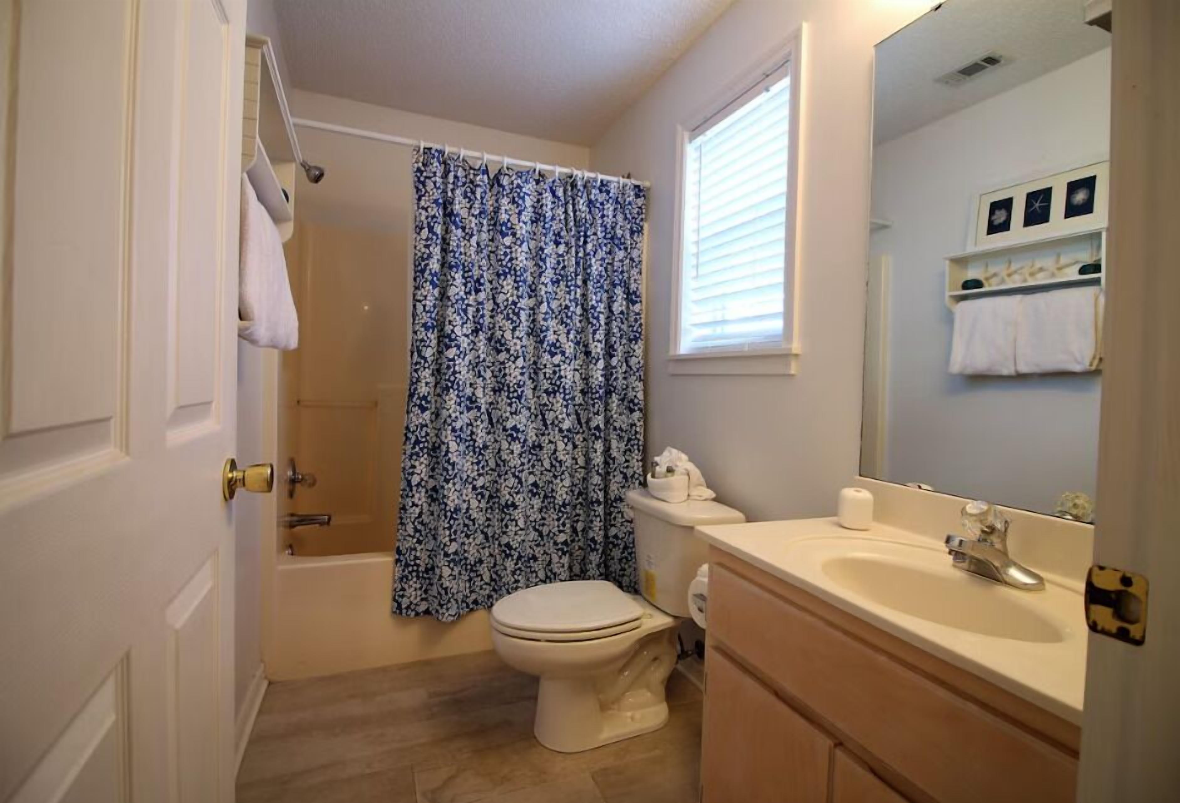 A bathroom with a toilet, sink, and shower.